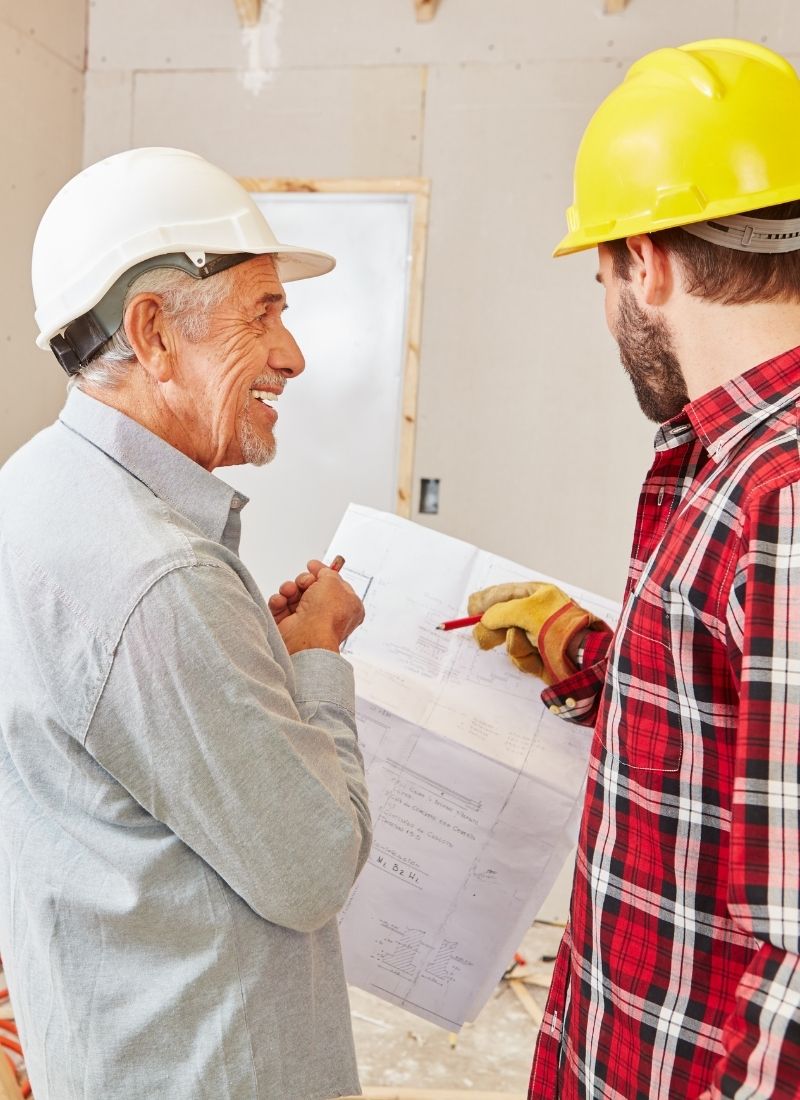 Erfahrener Bauleiter bespricht Renovierungsprojekt mit Handwerker in Südbaden